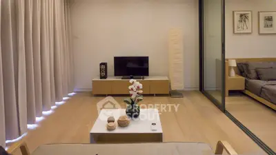 Modern living room with minimalist decor and sliding glass doors leading to a cozy bedroom.