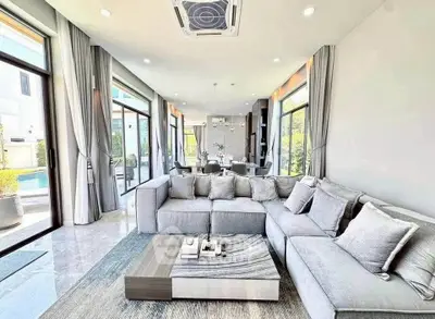 Luxurious modern living room with large windows and elegant decor, perfect for relaxation and entertaining.