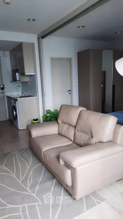 Modern apartment interior with cozy living room and compact kitchen area.