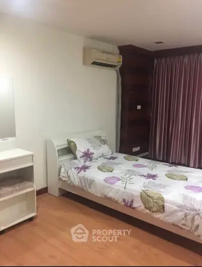 Cozy bedroom with floral bedding and air conditioning in modern apartment
