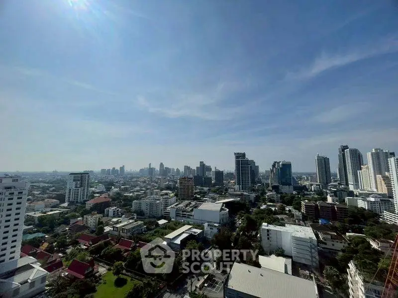 Stunning cityscape view from high-rise building showcasing urban skyline and greenery.