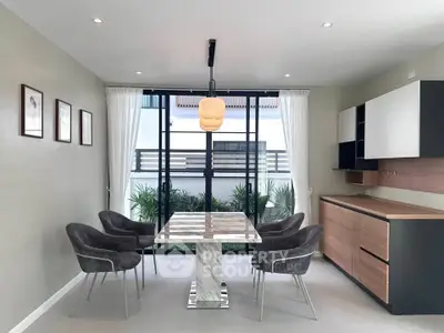Modern dining area with marble table and stylish chairs, featuring large windows and contemporary decor.