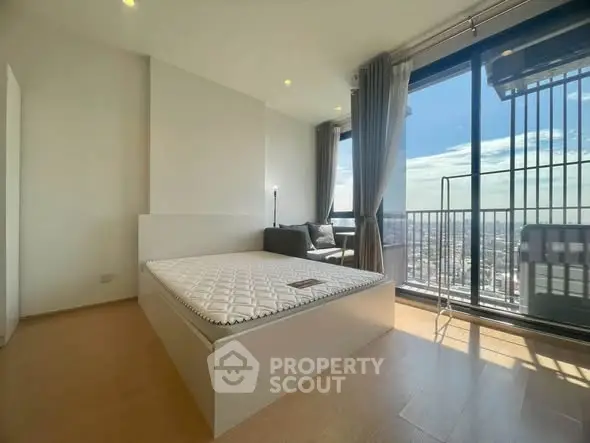 Spacious bedroom with stunning city view and large windows in modern apartment