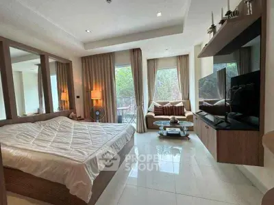 Spacious bedroom with modern decor and large windows offering natural light and garden view.