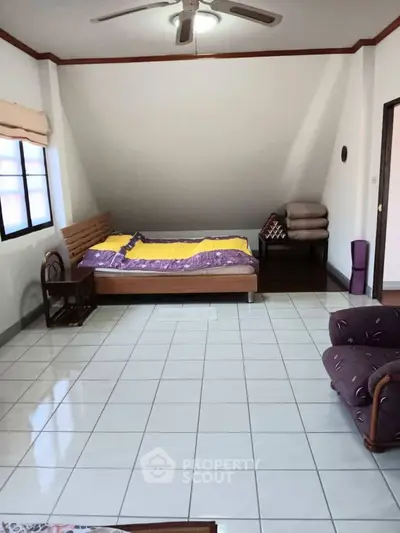 Spacious bedroom with sloped ceiling and cozy furnishings