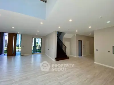 Spacious modern living room with elegant staircase and large windows