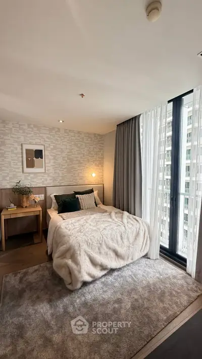 Cozy bedroom with modern decor and large window offering city view