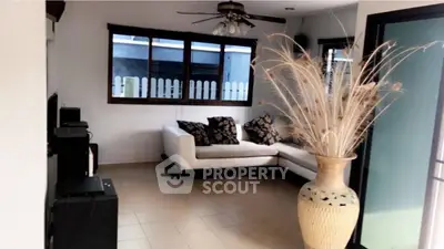 Cozy living room with modern decor and large vase, perfect for relaxation.