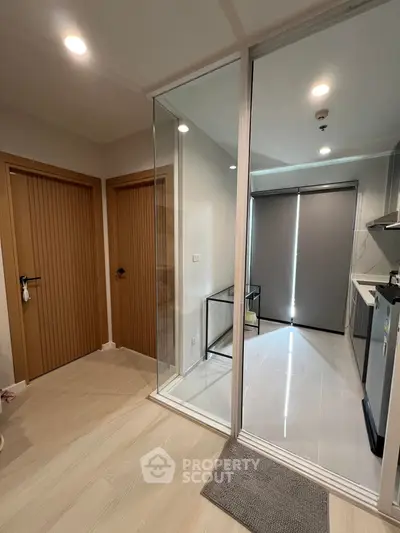 Modern apartment interior with glass partition and sleek kitchen design