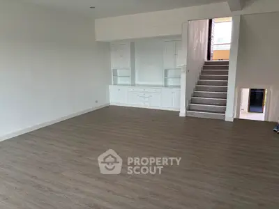 Spacious modern living room with elegant wooden flooring and built-in storage