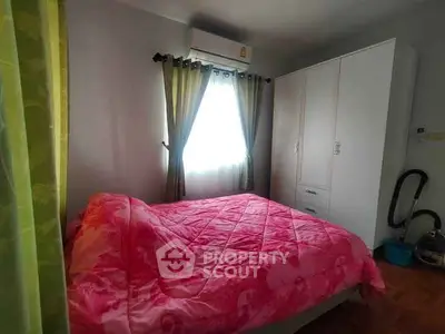 Cozy bedroom with vibrant pink bedding and ample natural light