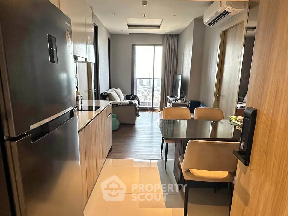 Modern apartment interior with open kitchen and cozy living area, featuring sleek design and city view.