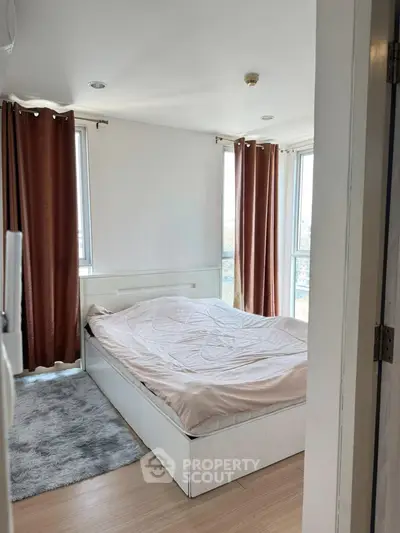 Cozy bedroom with large windows and elegant curtains in modern apartment