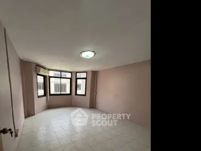 Spacious empty room with large windows and tiled floor, ideal for customization.