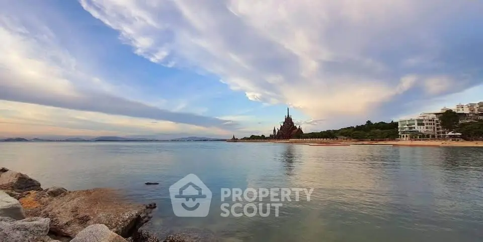 Stunning beachfront view with unique architectural landmark and serene waters.