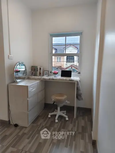 Charming study nook with desk, chair, and window view in cozy home.