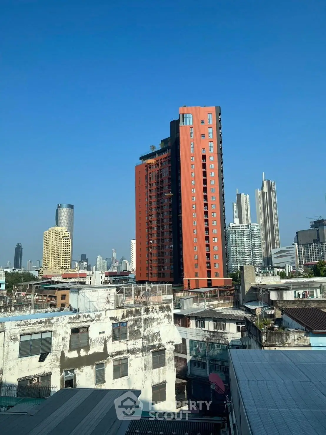 Stunning cityscape view featuring a modern high-rise building against a clear blue sky.