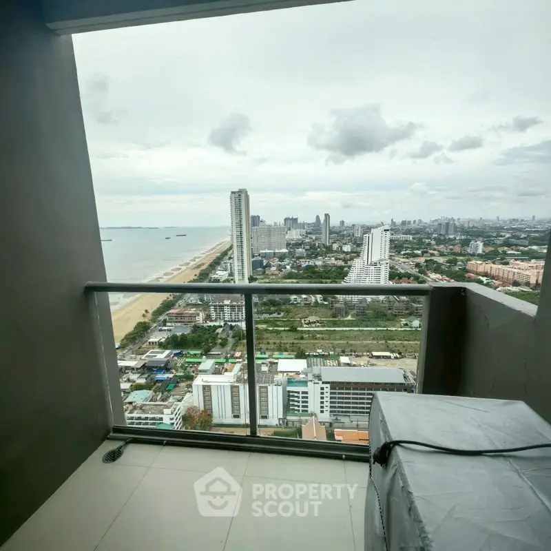 Stunning high-rise balcony view overlooking cityscape and ocean, perfect for urban living.