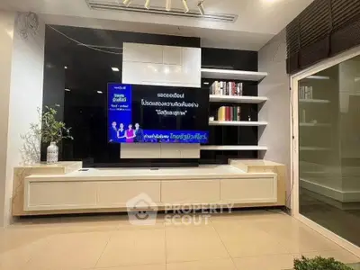 Modern living room with sleek entertainment center and built-in shelves.