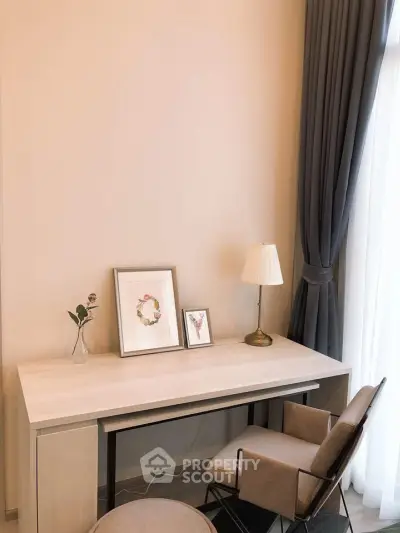 Elegant study area with modern desk, chair, and decor in a bright room.