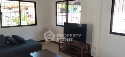 Spacious living room with modern sofa and large TV, perfect for relaxation.