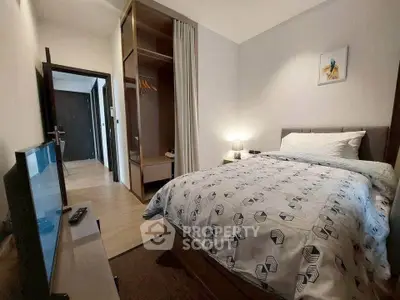 Cozy bedroom with modern decor and spacious closet in a stylish apartment.