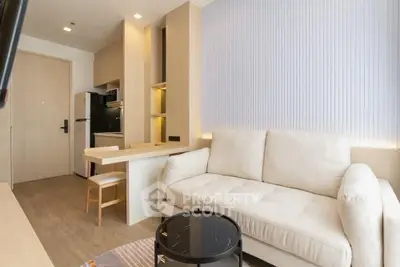 Modern living room with cozy sofa and stylish kitchen in open layout apartment.