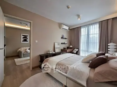 Spacious bedroom with modern decor and natural light, featuring a cozy bed and stylish furnishings.