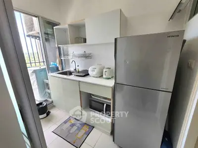 Compact kitchen with modern appliances and sleek cabinetry in a cozy apartment setting.