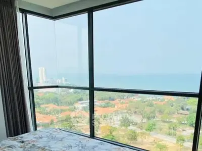 Stunning high-rise bedroom with panoramic ocean and city views.