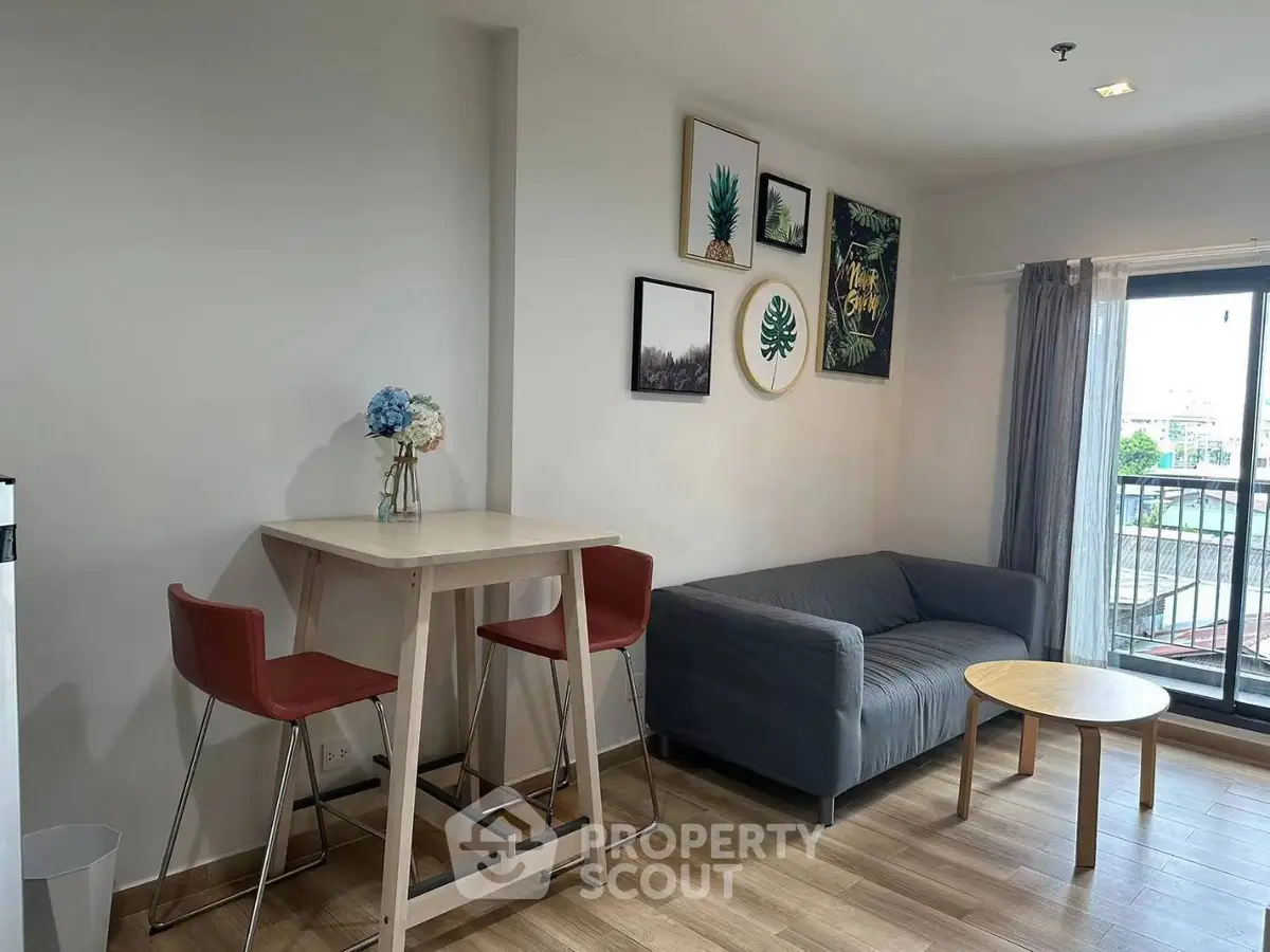 Modern living room with stylish decor and balcony view, featuring cozy seating and elegant wooden flooring.