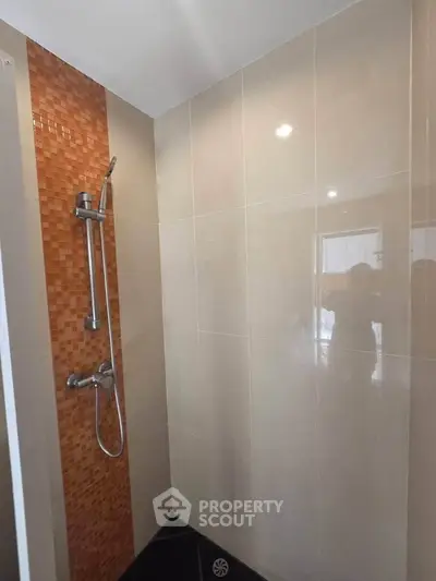 Modern bathroom with sleek shower design and stylish tile accents.
