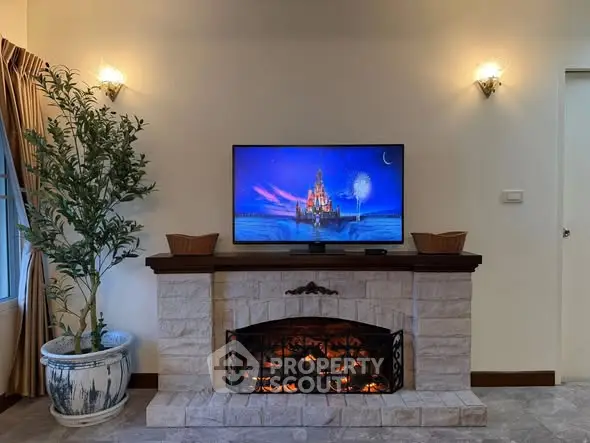 Cozy living room with elegant fireplace and mounted TV, perfect for relaxation and entertainment.