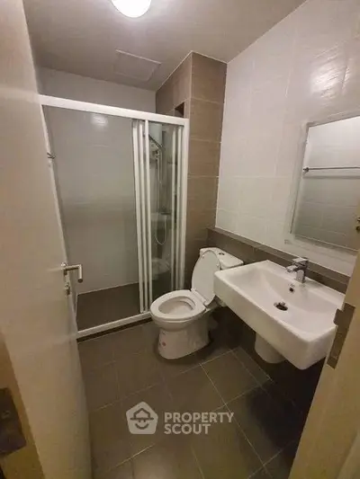 Modern bathroom with glass shower enclosure and sleek fixtures.