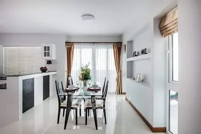 Modern dining area with sleek furniture and natural light in a stylish open-plan apartment.