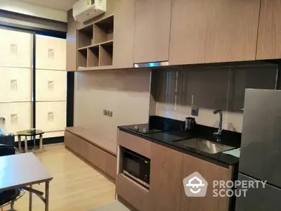 Modern kitchen with sleek wooden cabinetry and built-in appliances in a stylish apartment.