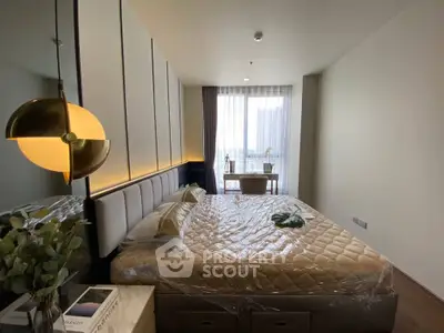 Modern bedroom with stylish decor and large window offering natural light