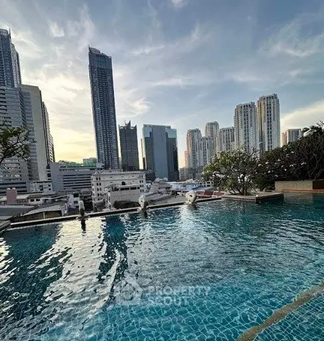 Stunning rooftop pool with breathtaking city skyline views at sunset.