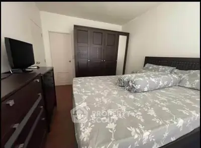 Spacious bedroom with elegant wooden furniture and floral bedding