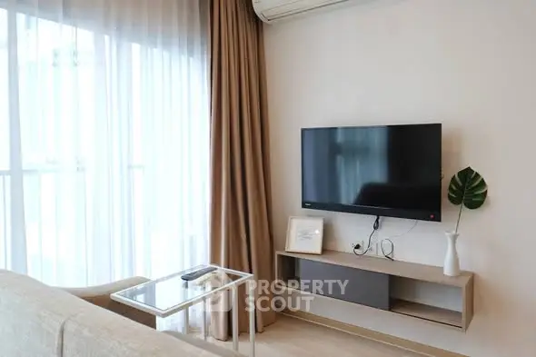 Modern living room with wall-mounted TV and elegant decor in a bright apartment.