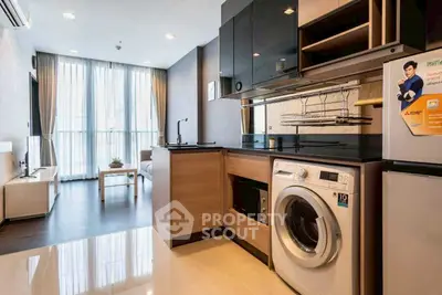 Modern kitchen with washing machine and sleek cabinetry in a stylish apartment.