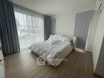 Spacious bedroom with large windows and modern decor