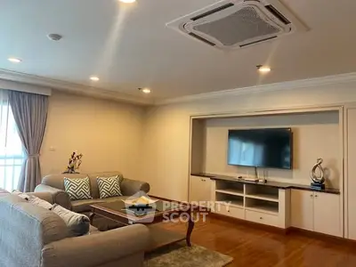Spacious living room with modern decor and wall-mounted TV, perfect for relaxation and entertainment.