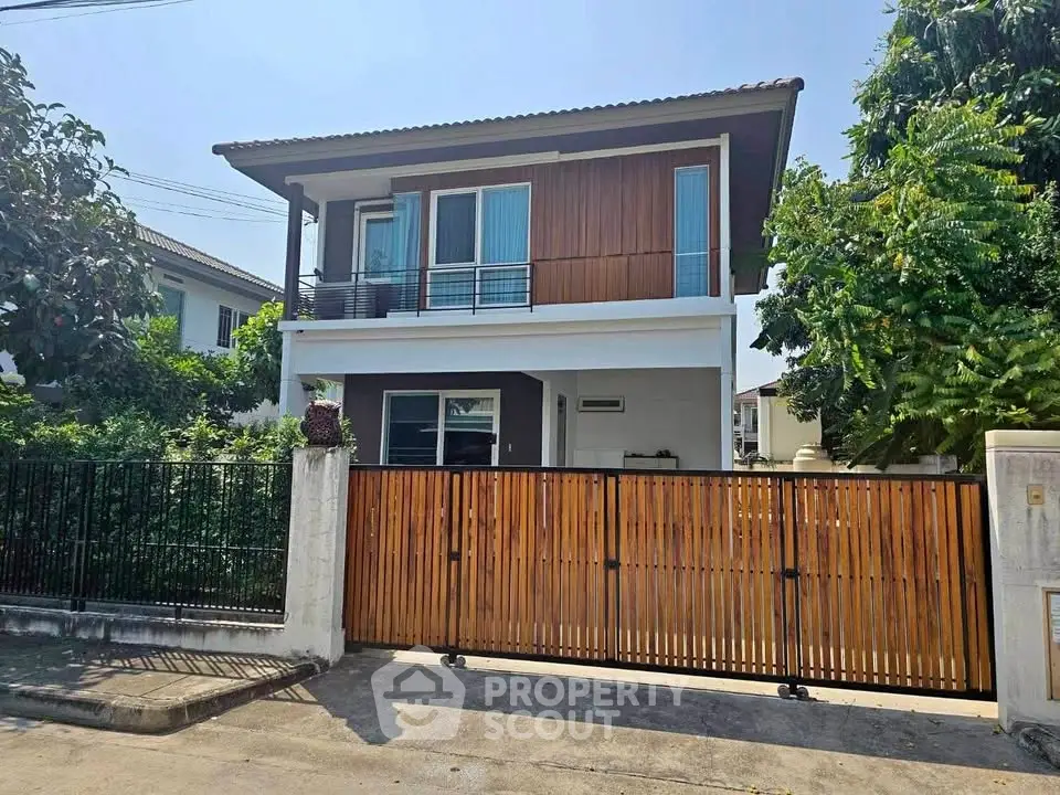 Charming two-story house with modern design and lush greenery, perfect for family living.