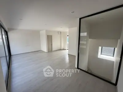 Spacious modern interior with large windows and sleek flooring, perfect for versatile living space.