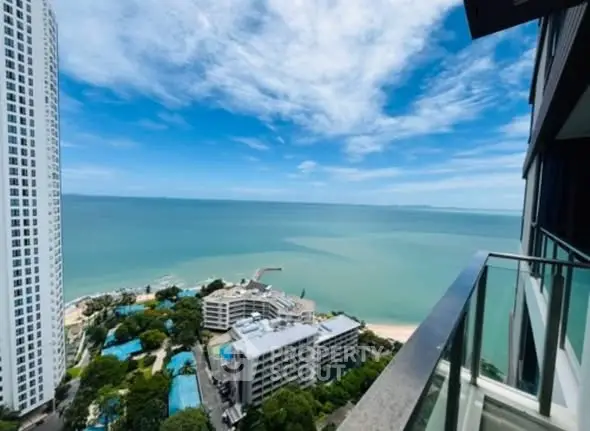 Stunning ocean view from high-rise balcony with clear blue skies.