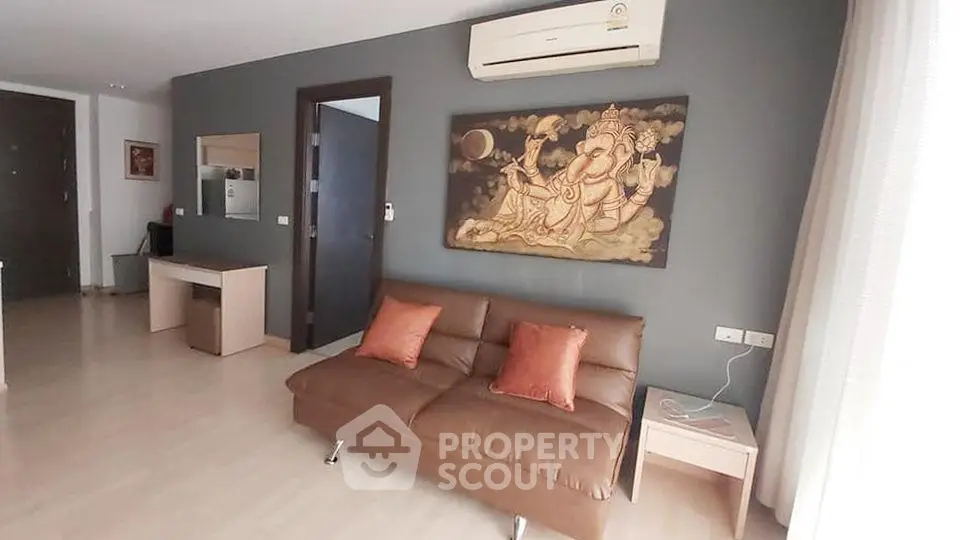 Modern living room with stylish decor and air conditioning, featuring a comfortable sofa and elegant artwork.
