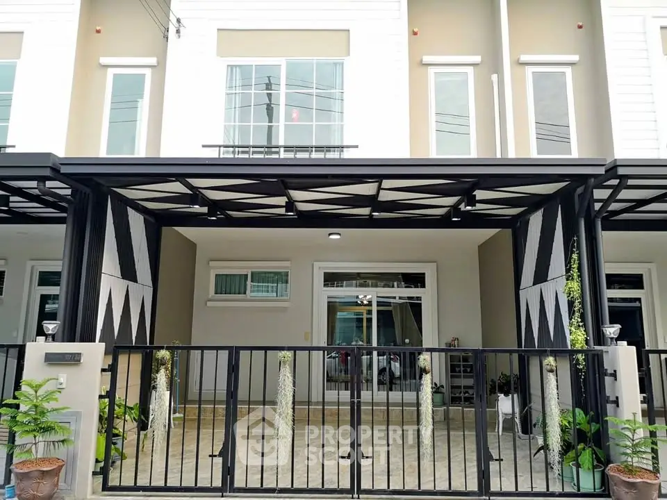 Modern townhouse exterior with stylish black metal gate and covered carport