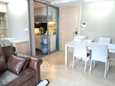 Modern open-plan living room with dining area and kitchen in a stylish apartment.