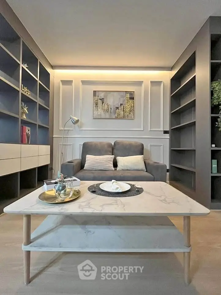 Modern living room with stylish decor and cozy seating area, featuring elegant shelving and ambient lighting.